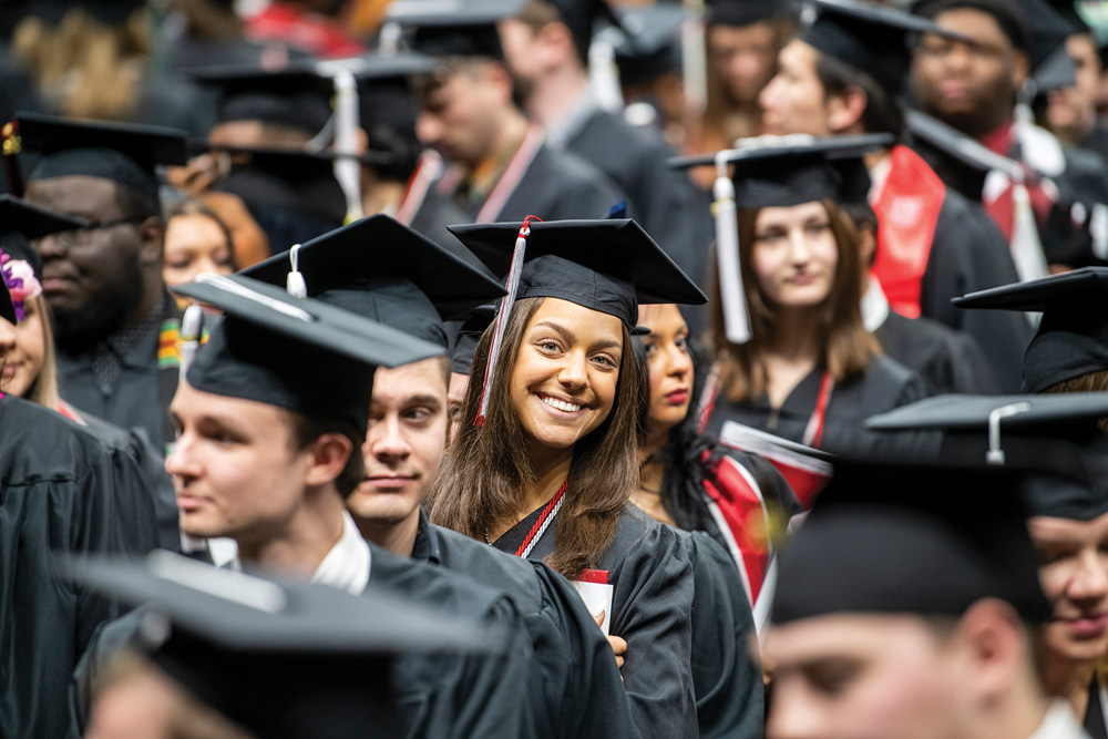 Female graduate smiling at camera at commencement